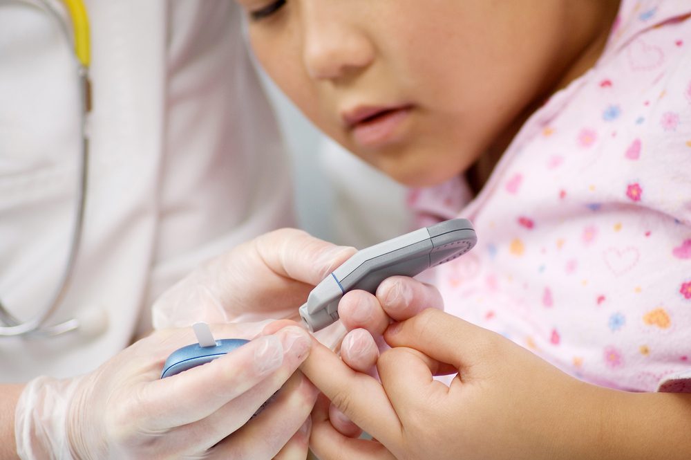 child getting finger stick for diabetes